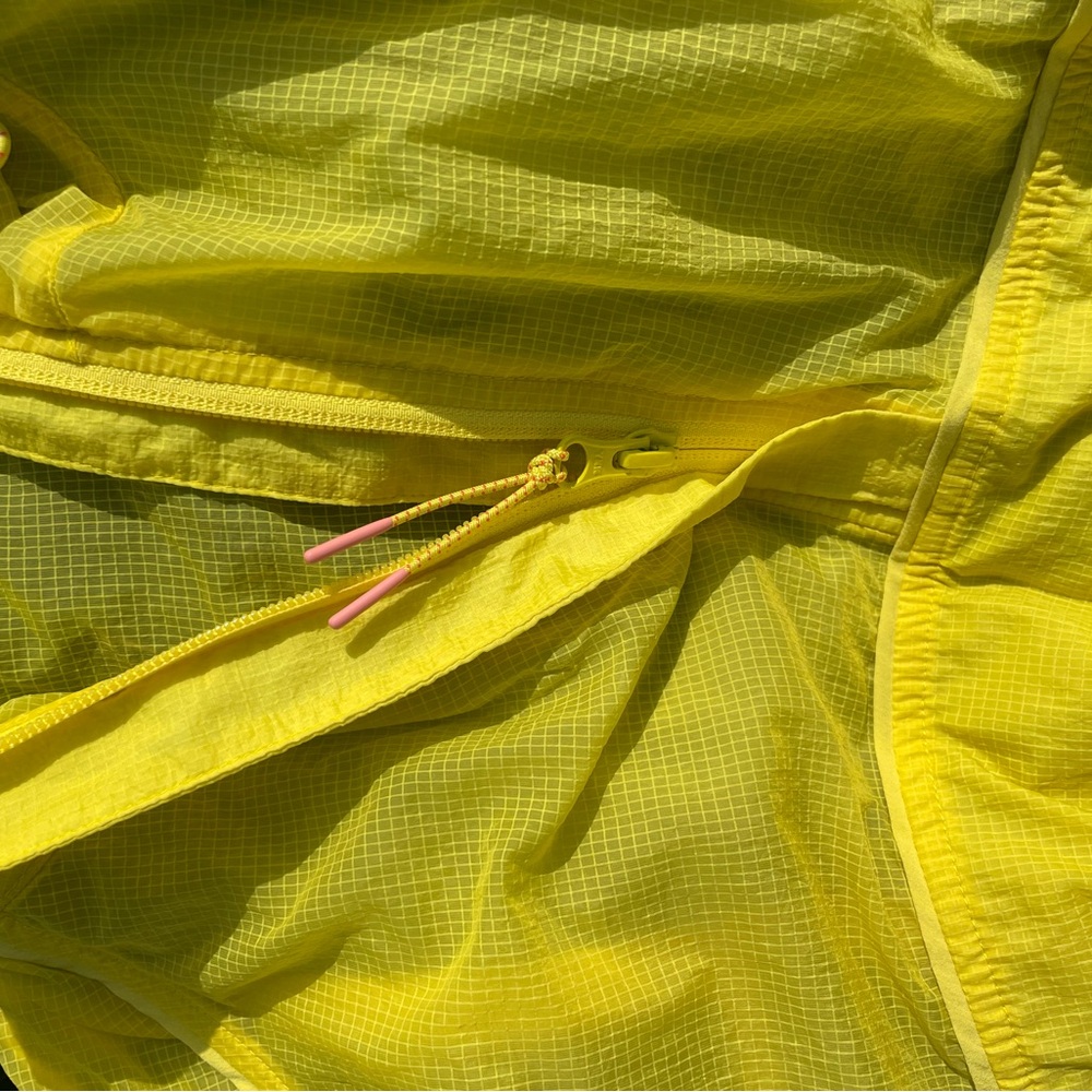 Bright yellow Outdoor Voices running wind jacket.